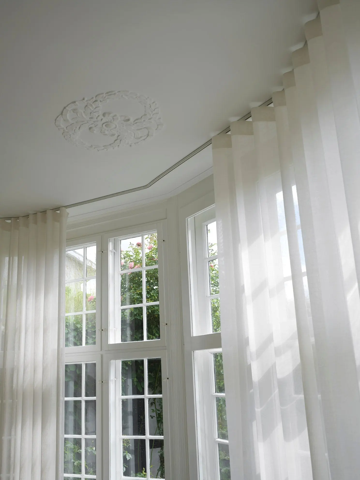 White wave curtains following a rounded ceiling track